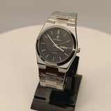 Silver watch on a stand with a neutral background