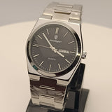 Silver watch on a stand with a gray background