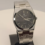 Silver watch on a stand with a gray background