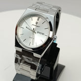 Silver watch on a black stand against a gray background