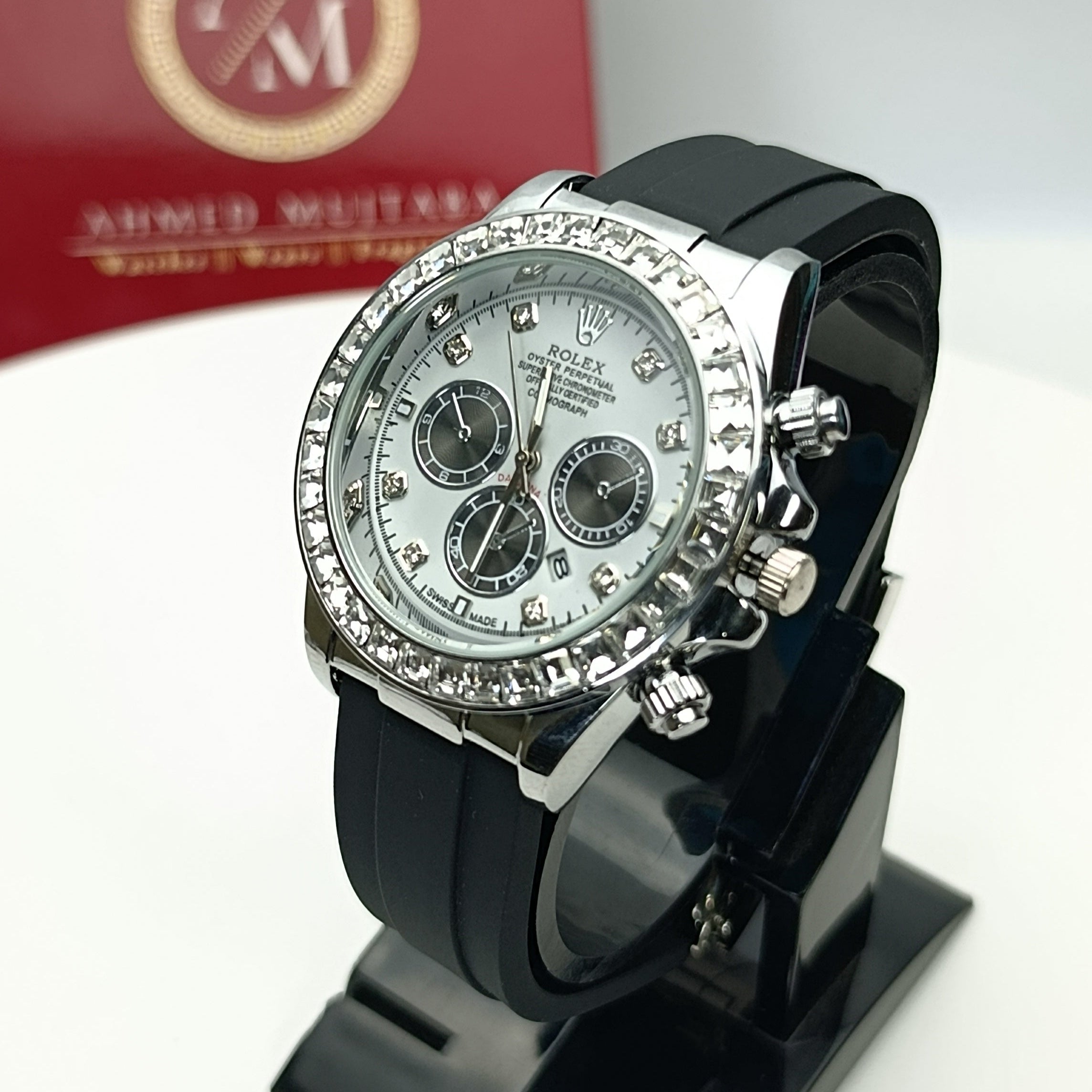 Black watch with silver bezel on a stand, brand box in the background