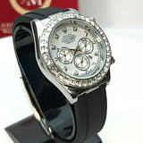 Luxury watch with black strap and silver case on a stand, with a brand box in the background.