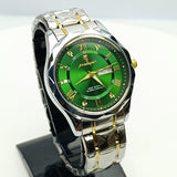 Wristwatch with green face and silver and gold case on a white background