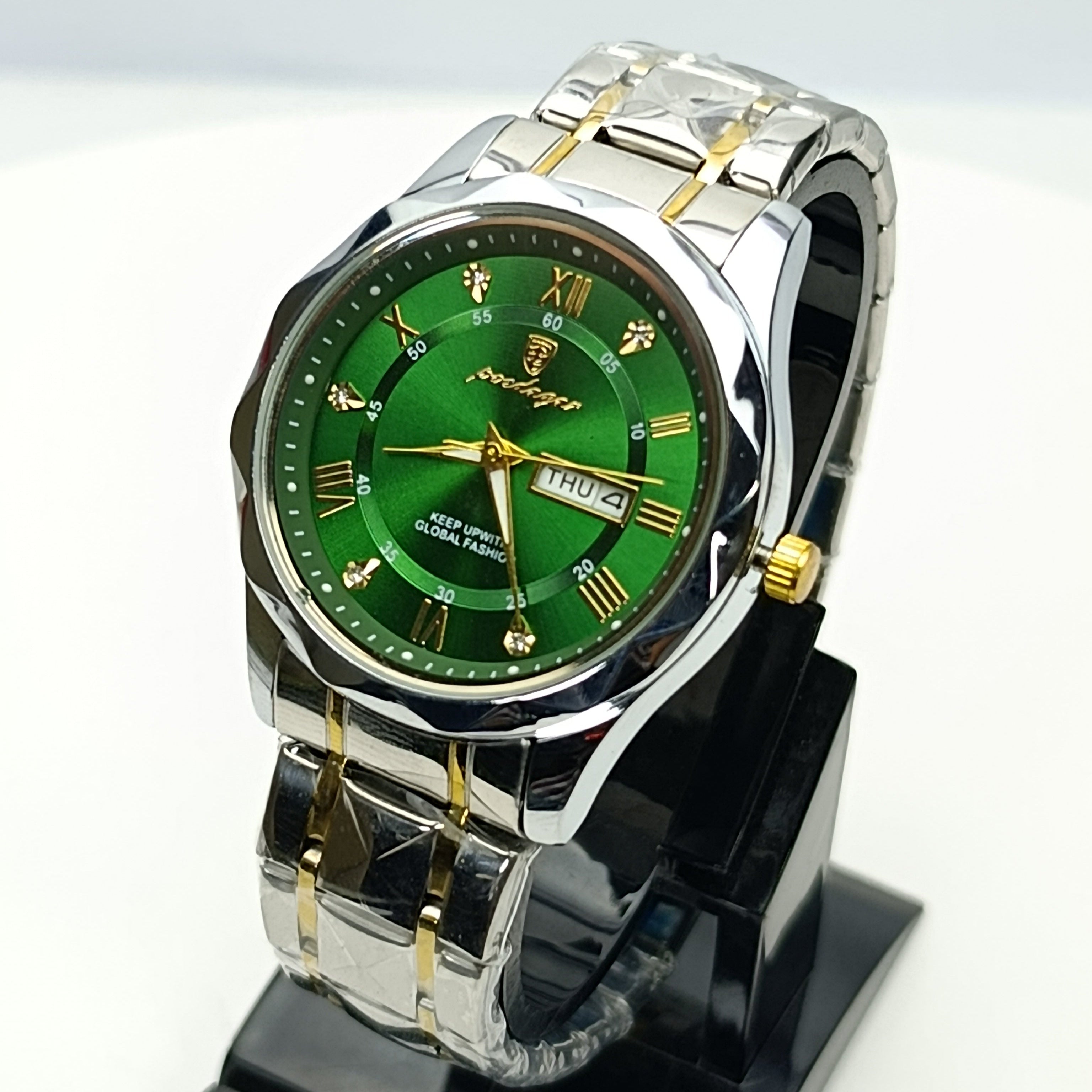 Wristwatch with green dial and silver and gold band on a white background