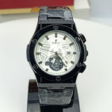 Hublot watch with black and silver design on a white surface, brand name visible