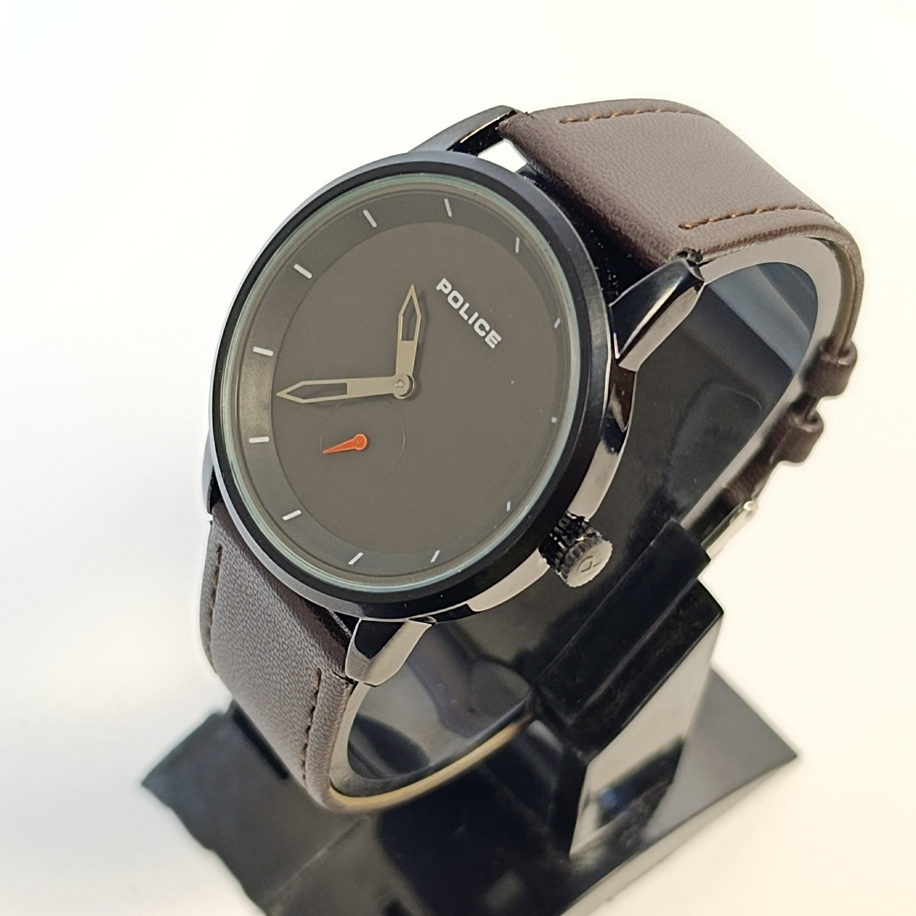 Police watch with brown leather strap on a stand against a white background