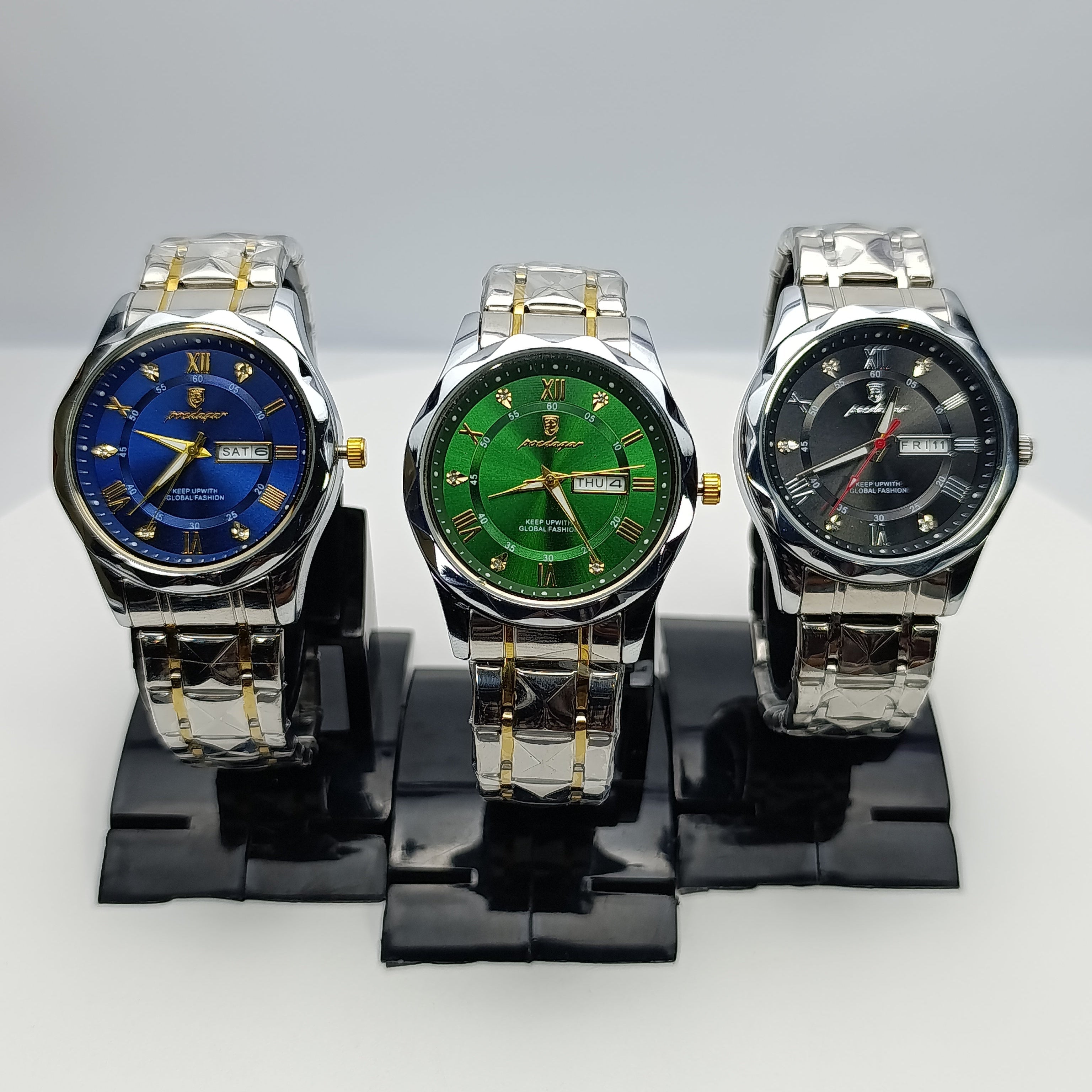 Three watches with different colored faces on a stand against a white background